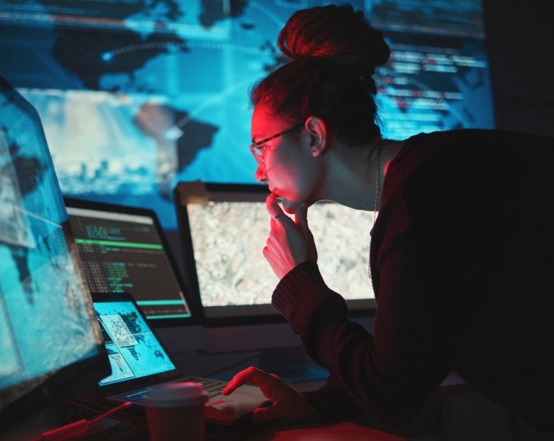Analyst reviewing digital information and intelligence data in a forensic analysis setting.