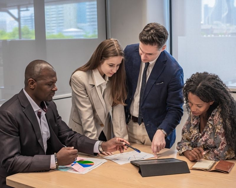 Corporate professionals analysing reports and data together, supporting forensic investigation and business intelligence work.