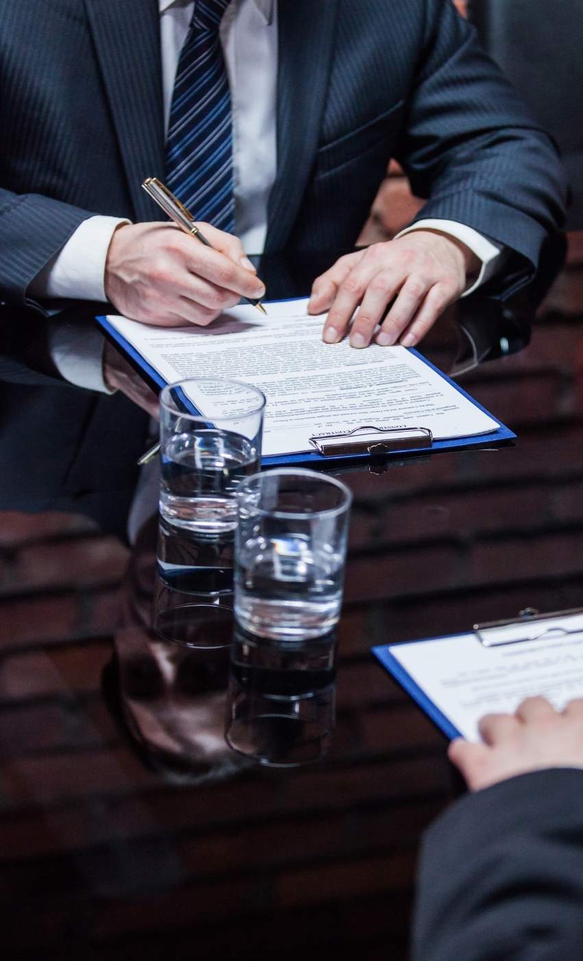 Grudko Associates - Litigation Support Evidence Preparation and Document Review South Africa Legal professionals signing and reviewing formal documents as part of a litigation support investigation, reflecting evidentiary preparation, document verification and court-ready case development.