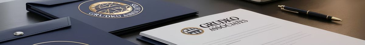 Grudko Associates branded folders and documents with a gold-embossed logo, arranged alongside a laptop, notebook and pen, reflecting forensic investigations, legal documentation.