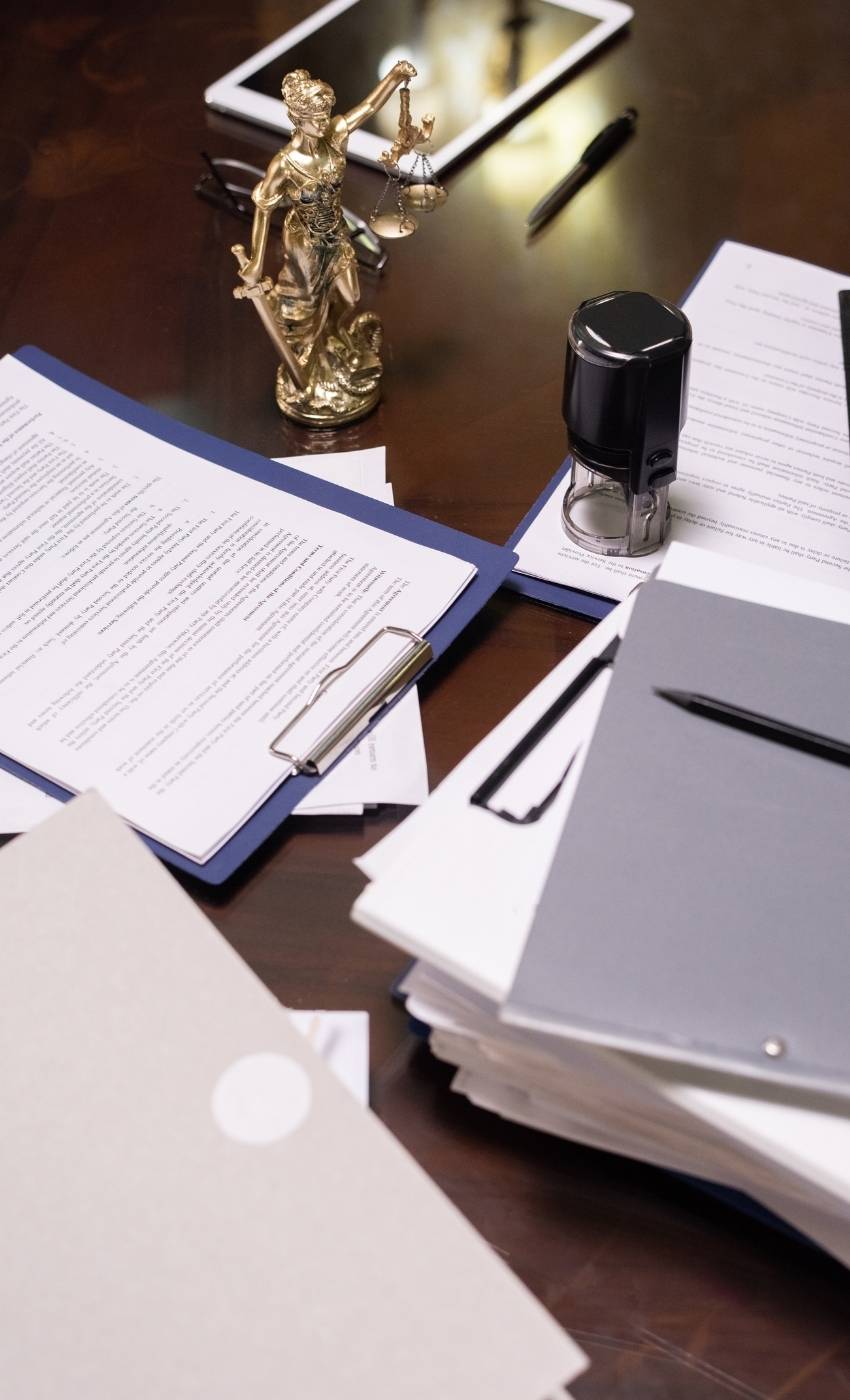 Litigation Support Evidence Files and Document Analysis Stacked legal documents and evidentiary files on a desk with scales of justice, representing forensic litigation support, document analysis and court-ready case preparation.