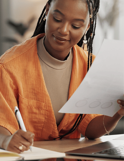 Professional reviewing documents and making notes at a desk, reflecting due diligence analysis, background checks and evidence-based decision-making in a corporate setting. Professional reviewing documents and making notes at a desk, reflecting due diligence analysis, background checks and evidence-based decision-making in a corporate setting.